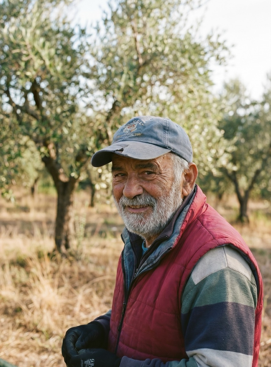 Tommaso Conti, second-generation olive farmer, smiling among his olive trees in Tuscany